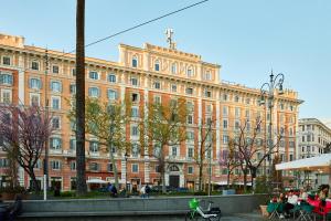 a large brick building with people sitting in front of it at Residenza Alferini - San Pietro in Rome