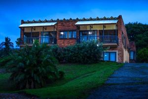 Una casa de ladrillo con un camino delante de ella. en Ikhthus Accommodation N, en Hibberdene