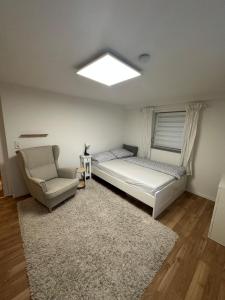 a bedroom with a bed and a couch and a chair at Zentrales & ruhiges Appartment in Schwäbisch Hall