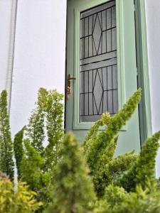 a green door with a window on a house at VM Cozy Home - Kokkari Center in Kokkari