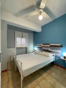 a bedroom with a bed with a blue wall at Appartamento VITARI in Roseto Capo Spulico