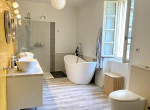 a bathroom with two sinks and a tub and a toilet at Domaine La Buissière Duravel "La Maison" Piscine privative in Duravel +9 photos