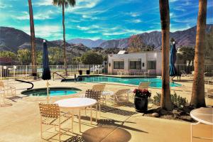 ein Resort mit Pool und Stühlen und einem Gebäude in der Unterkunft The Miramonte Bungalow in Palm Springs