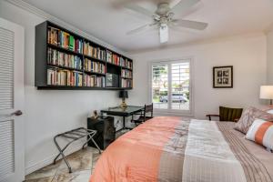 ein Schlafzimmer mit einem Bett und einem Bücherregal mit Büchern in der Unterkunft The Miramonte Bungalow in Palm Springs