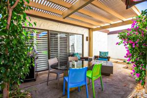 eine Terrasse mit Tisch und Stühlen und Blumen in der Unterkunft The Miramonte Bungalow in Palm Springs