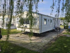 ein Mobilheim vor einem Haus in der Unterkunft Southview Holiday park caravan in Winthorpe