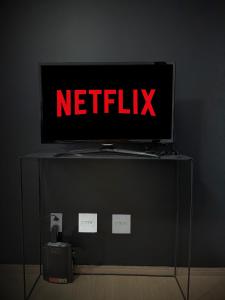 een tv op een standaard met een Netflix-bord erop bij Prático Viena - Free Parking - 24 hour doorman in Parque Industrial
