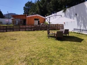 a building with a table and chairs and an umbrella at ESTANCIA 360 HERMOSA CABAÑA PARA PAREJA O FAMILIA in Zacatlán