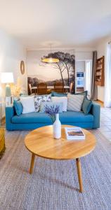 a living room with a blue couch and a table at AC - Reserved parking - Villa La Farigoulette in Les Angles Gard