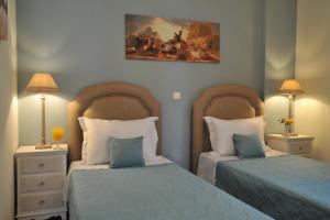 カテリオスにあるApartments Valta Viewのベッドルーム1室(ベッド2台、ランプ2つ、絵画付)