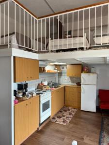 a kitchen with wooden cabinets and a white refrigerator at Nature Paradise Apartment in Karditsa