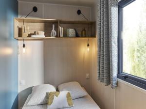 a room with two pillows on a bed with a window at Camping LE MOULIN DE CAUDON in Domme +38 photos