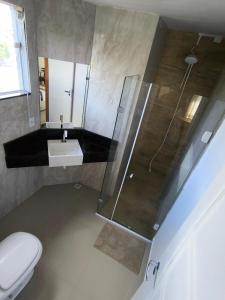 a bathroom with a shower and a toilet and a sink at Vista da Serra in Penedo +7 photos