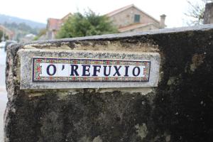 a sign on the side of a stone wall at O Refuxio de la Jerezana in Redondela