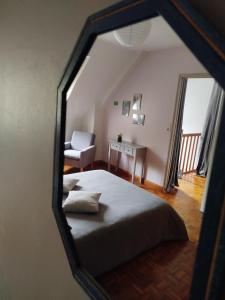 a view of a bedroom with a bed and a chair at Les Colibris in Tréhorenteuc