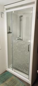 una puerta de ducha de cristal en un baño con lavabo en Argeles Mobil'holidays del mar camping 222, en Argelès-sur-Mer