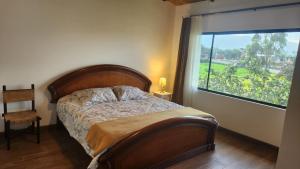 a bedroom with a bed and a large window at La Cuadra - Hospedaje en Puembo in Puembo