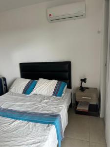 a bedroom with a bed with a black headboard at Cuarto privado in Santa Cruz de la Sierra