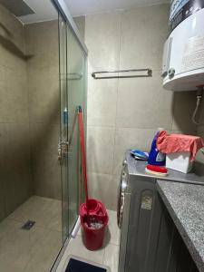 a bathroom with a glass shower with a red shovel at Cuarto privado in Santa Cruz de la Sierra