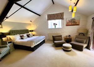 ein Schlafzimmer mit einem Bett und einem Stuhl und einem Fenster in der Unterkunft Ravenstone Lodge Country House Hotel in Keswick