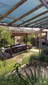 a picnic table under a pavilion in a garden at Casa Moksha in Máncora