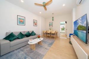 a living room with a couch and a tv at Winks Beach Patong Phuket in Patong Beach