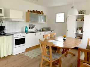 a kitchen with a wooden table and a dining room at Three Bedroom Cottage Scenic Farm Views Lake Access and Free Boat in Valdemarsvik