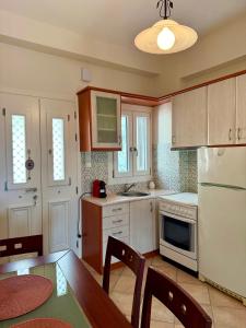 a kitchen with a table and a white refrigerator at SyrasView in Ermoupoli +13 photos