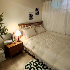 a bedroom with a large white bed and a nightstand at Lala Stay in Seoul