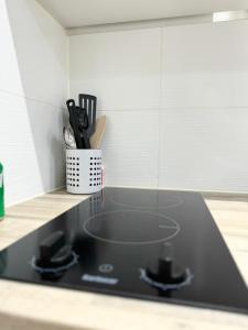 a black stove top in a kitchen with knives at Light & Lamp, En-Suite Studio, in Woolwich in Woolwich