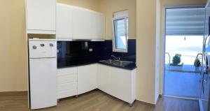 a kitchen with white cabinets and a sink and a window at Horizonte Blu in Borsh