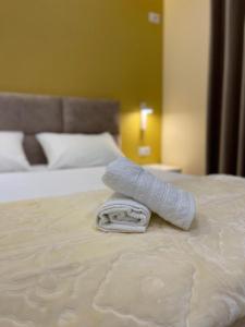 a rolled up towel on top of a bed at Horizonte Blu in Shkalle Stenojt
