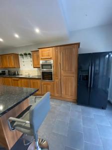 a kitchen with wooden cabinets and a blue refrigerator at 3 Bedroom House in Cardiff in Cardiff +19 photos
