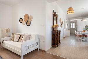 a living room with a white couch and a dining room at Citrine in Naousa