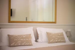 Un espejo sobre una cama con dos almohadas. en B&B Le Grazie, en Bérgamo