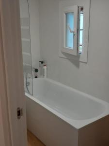 a white bathroom with a tub and a window at La cabaña de Paredes in Paredes de Buitrago +43 photos