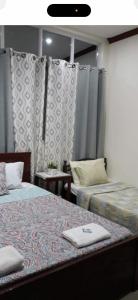 a room with two beds with curtains and a bed sidx sidx sidx at S & E homes 2 in Babuy