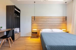 a bedroom with a bed and a desk with a chair at Blue Velvet Coast Luxury Villas in Kokkíni Khánion