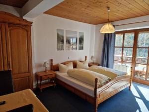 a bedroom with a bed and a large window at Pension Aufeld in Landsberg am Lech