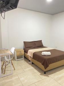 a bedroom with a bed and a table and a desk at Daresff Imperial in Puerto Wilches