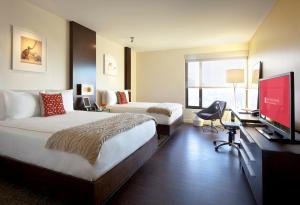 a hotel room with a bed and a flat screen tv at The Alexander in Indianapolis