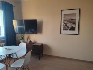 a living room with a table and a flat screen tv at Natalia in Puck