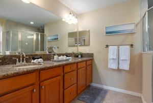 une salle de bain avec un lavabo et un grand miroir dans l'établissement Modern DT Home-King size Bed-Patios-Long Stays-WiFi, à Orlando 69 autres photos