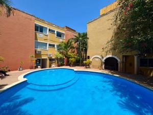 a large blue swimming pool in front of a building at Suites Cancun Center in Cancún