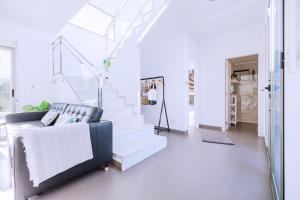 a living room with a couch and stairs at Casa Coco Stylisches Beachhouse mit Pool & Sundeck Els Poblets Denia in Els Poblets +45 photos