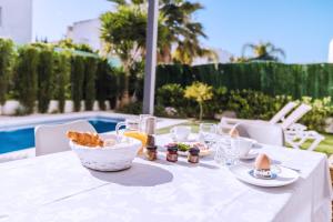 a white table with a bowl of food on it at Casa Coco Stylisches Beachhouse mit Pool & Sundeck Els Poblets Denia in Els Poblets