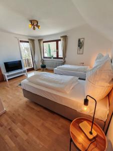 Un dormitorio con dos camas y una mesa con lámpara. en Das Familien Nest by ALA Living - LEGOLAND in 8min! - privater Garten & Grill, en Leipheim