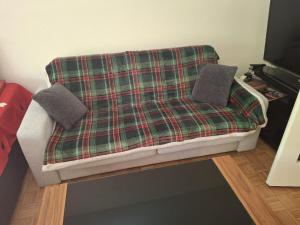 a couch with a plaid blanket on it at Apartment in Basel Eurovision! in Basel