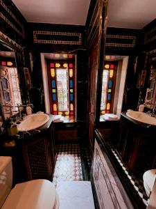 un bagno con 2 lavandini e vetrate istoriate di Kassr Annoujoum - Luxury Boutique Riad in the Heart of Fès Medina a Fes