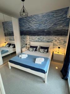 a bedroom with a large bed with a painting on the wall at Terrasini Sea in Terrasini